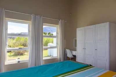 a bedroom with a bed and a window and a desk at Porcupine Creek in Pringle Bay