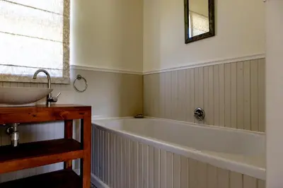 a bathroom with a bath tub and a sink at Porcupine Creek in Pringle Bay