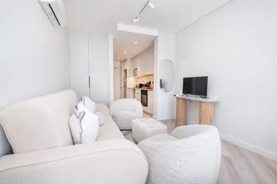 a living room with white furniture and a tv at 232 Paarl Studio With AC and Onsite Parking in Paarl