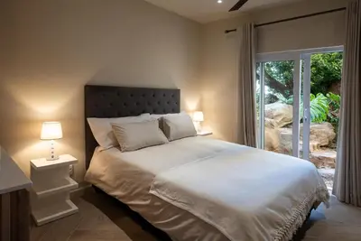 a bedroom with a large white bed and a window at Villa Solara, 6 bedroom Vacation Villa with sea view in Gordonʼs Bay