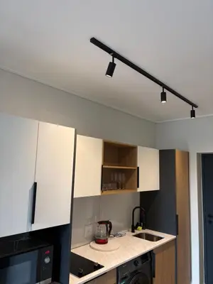 a kitchen with white cabinets and a black appliance at Urban Ridge in Cape Town