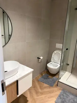 a bathroom with a toilet and a sink and a mirror at Urban Ridge in Cape Town