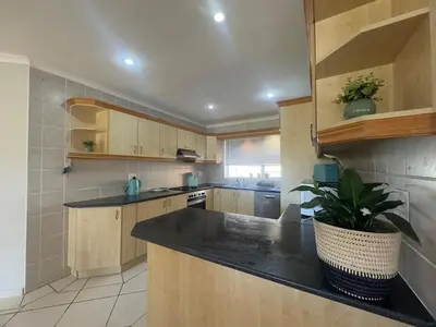 a kitchen with wooden cabinets and a potted plant at Sunset View in Durbanville