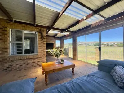 a room with a bed and a table with flowers on it at Sunset View in Durbanville