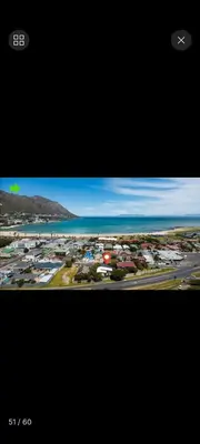 a view of a city with the ocean and houses at Beach House Living in Gordonʼs Bay