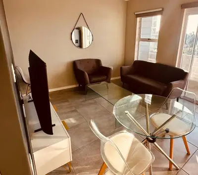 a living room with a glass table and a couch at Table Mountain View Apartment II in Cape Town