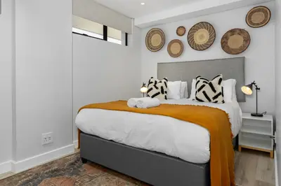 a bedroom with a large bed and some plates on the wall at Burmeister Modern 2-Bedroom w/ Views Milnerton in Cape Town