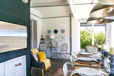 a room with a table and chairs and a dining room at The Bay Cottage in Pringle Bay