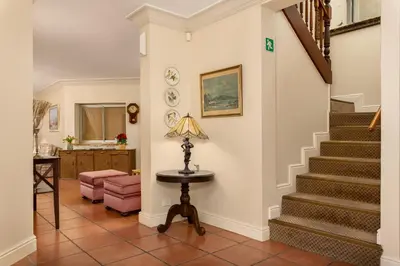 a living room with a staircase and a table at Gable Manor by Neighbourgood in Franschhoek