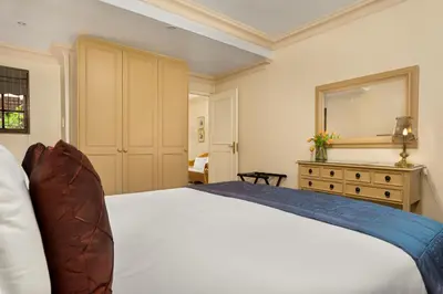 a bedroom with a large white bed and a dresser at Gable Manor by Neighbourgood in Franschhoek