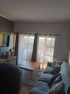 a living room with a couch and a coffee table at Central 3rd Floor Durbanville Apartment in Durbanville