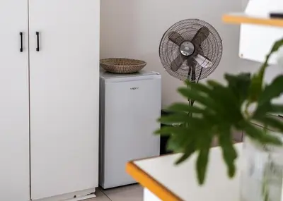 a fan sitting on top of a refrigerator at Private Garden Flat in Die Boord with Secure Parking in Stellenbosch