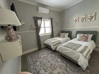 a bedroom with two beds and a window at A home away from home near the beach in Strand