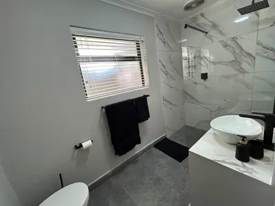 a white bathroom with a sink and a toilet at A home away from home near the beach in Strand