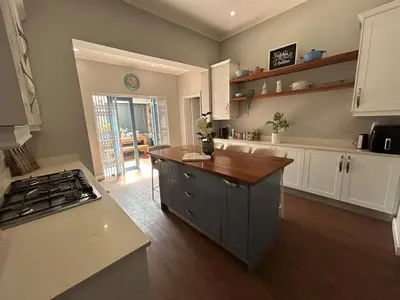 a kitchen with a counter and a stove top oven at A home away from home near the beach in Strand
