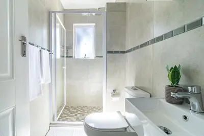 a bathroom with a shower and a toilet and a sink at Flatlet on Circle in Cape Town