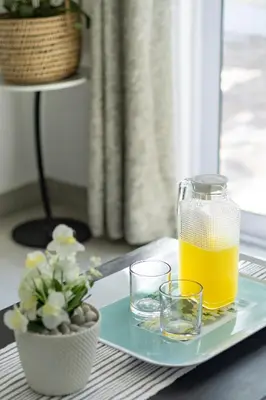 a glass of orange juice and two glasses on a tray at Flatlet on Circle in Cape Town