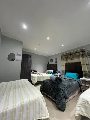 a bedroom with three beds in a room at claremont AN guesthouse in Cape Town