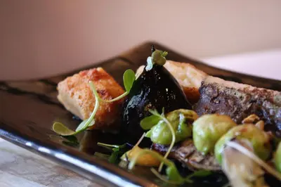 a plate of food with meat and vegetables on a table at Erinvale Estate Hotel & Spa in Somerset West