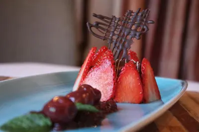 a blue plate with fruit and berries on a table at Erinvale Estate Hotel & Spa in Somerset West