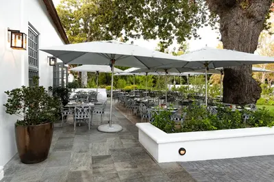 a patio with tables and chairs and umbrellas at Erinvale Estate Hotel & Spa in Somerset West