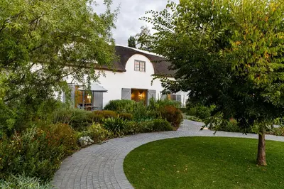 a house with a walkway in front of a yard at Erinvale Estate Hotel & Spa in Somerset West
