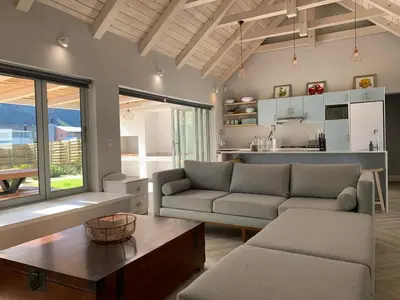 a living room with a couch and a table at Taylah's Hideaway in Bettyʼs Bay