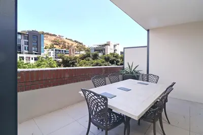 a table and chairs on the balcony of a building at City Vibes and Mountain Highs 2 Bed, 2 Bath Apart