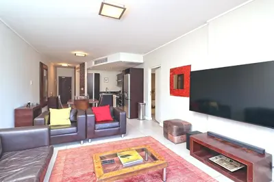 a living room with couches and a large flat screen tv at City Vibes and Mountain Highs 2 Bed, 2 Bath Apart