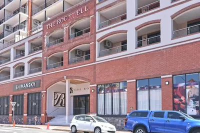 two cars parked in front of a brick building at City Vibes and Mountain Highs 2 Bed, 2 Bath Apart