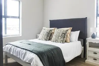 a white bedroom with a bed with pillows at Flat in Security Estate - Zomerwind Apartments in Oakdale