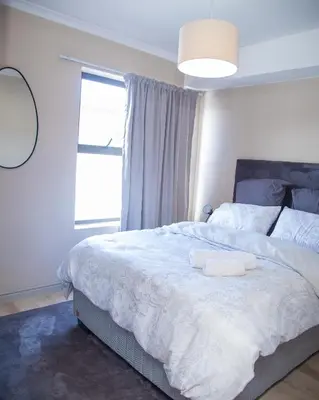 a bedroom with a bed with two towels on it at Cape on Viola in Cape Town