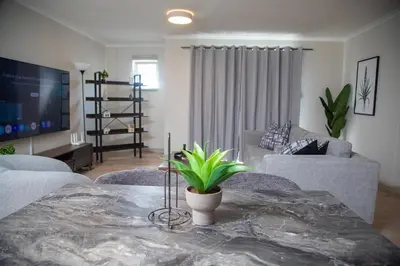 a living room with a table with a plant on it at Cape on Viola in Cape Town