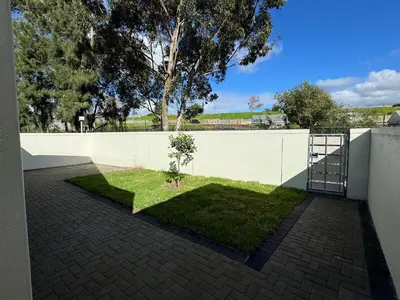 a white fence with a small tree in a yard at Montblanc 3 Bed 3 Bath House in residential security Estate in Stellenbosch