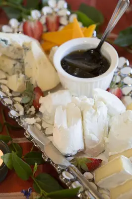 a plate of cheese and a bowl of sauce at Franschhoek Country House & Villas in Franschhoek