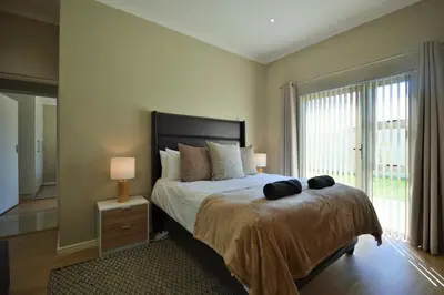 a bedroom with a bed and a large window at Montbleu 3 Bed 3 Bath House in residential security Estate in Stellenbosch