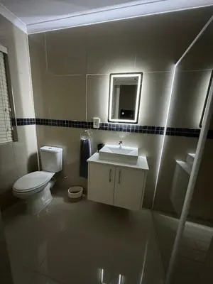 a bathroom with a toilet and a sink and a mirror at Montbleu 3 Bed 3 Bath House in residential security Estate in Stellenbosch