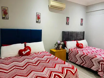 a bedroom with two beds with red pillows on them at Annika`s dormitory in claremont in Cape Town
