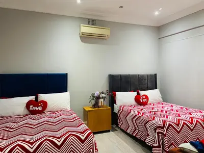 two beds with red heart pillows in a room at Annika`s dormitory in claremont in Cape Town