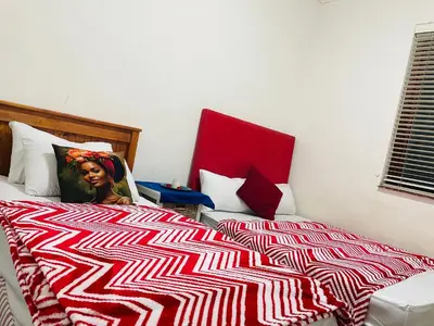 a woman sitting on a bed in a bedroom at Annika`s dormitory in claremont in Cape Town