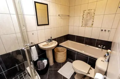 a bathroom with a sink and a toilet and a tub at The Palm in Kraaifontein