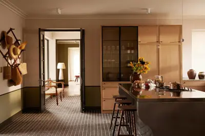 a kitchen with a counter and a kitchen island with chairs at The Manor House at Colmant in Franschhoek
