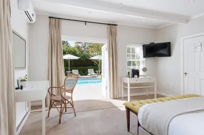 a hotel room with a bed and a desk and a table at River Manor Boutique Hotel by The Living Journey Collection in Stellenbosch