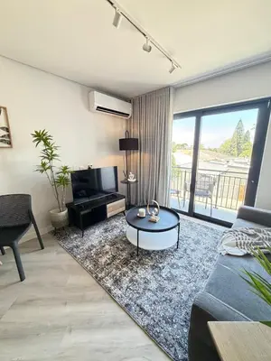 a living room with a couch and a table at Platform 123 - 2 On Tabak with onsite Parking in Paarl