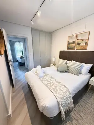 a large white bed in a room with at Platform 123 - 2 On Tabak with onsite Parking in Paarl
