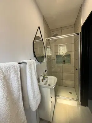 a bathroom with a sink and a shower with towels at Pelikaan 5 in Stellenbosch