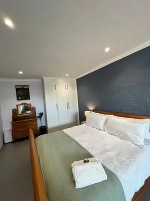 a bedroom with a large bed with a blue wall at Pelikaan 5 in Stellenbosch