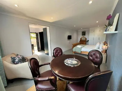 a room with a table and chairs and a bed at Pelikaan 5 in Stellenbosch