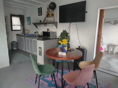 a kitchen with a table and two chairs and a table at Cocos Island in Bettyʼs Bay