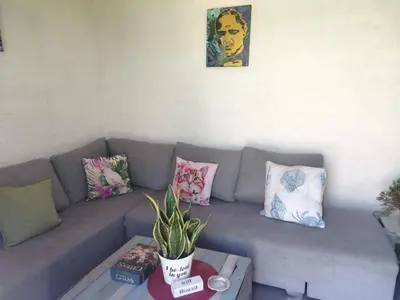 a living room with a couch with pillows and a table at Cocos Island in Bettyʼs Bay
